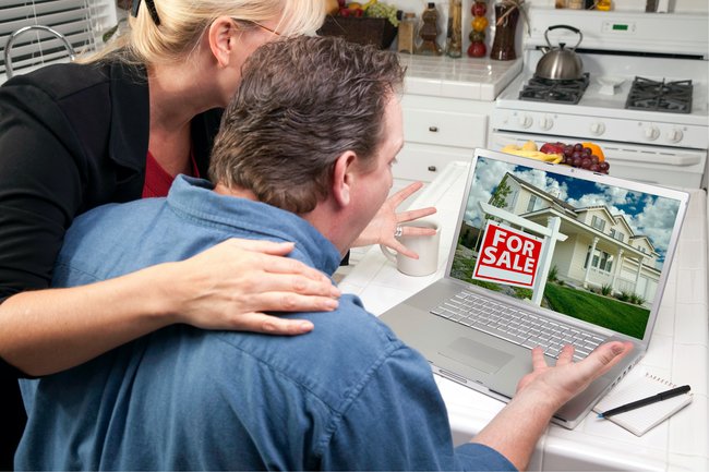 Couple looking at a computer for a new house in Pam rumley's World.