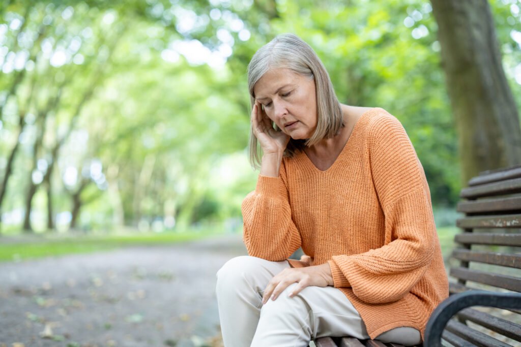 Woman sitting on a bench tired from iodine deficiency