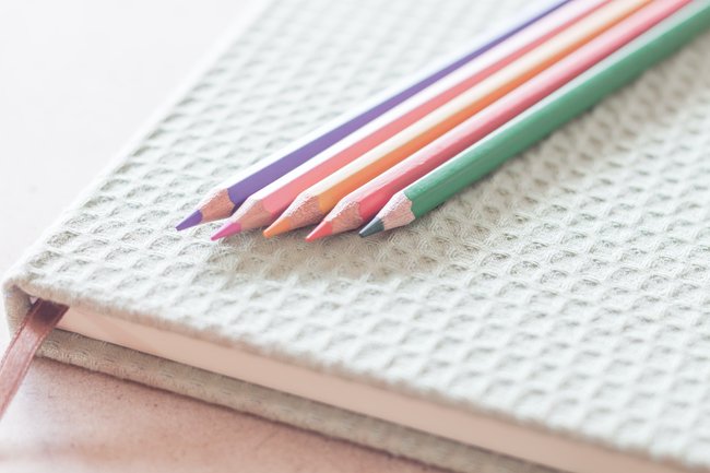 Photo of a white Coloring Journal with pencils relating to Coloring Journal for Stress Rellief