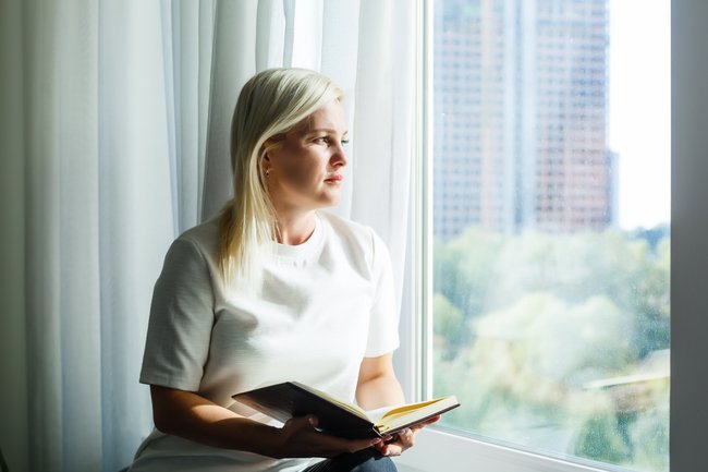 Photo of a woman sitting by a window relating to Prayer Life