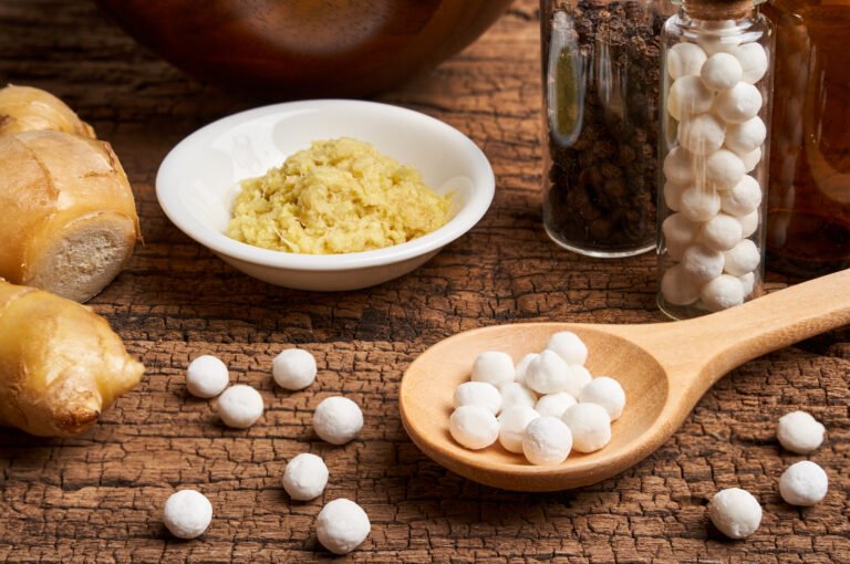 Photo of Homeopathy pills in a wooden spoon relating to what you should know about homeopathy