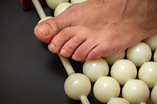 Foot using a massage roller to help improve circulation and relieve numb toes or tingling in the feet.