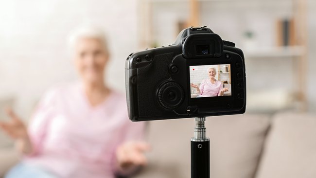 Senior woman recording video at home as a way to earn income with low physical effort