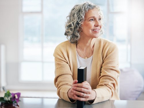 Mature woman holding a Bible, reflecting on faith and life experiences of strong women of the Bible.