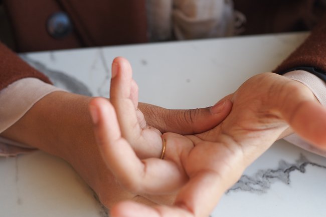 Person rubbing and massaging their hands to relieve tingling, numbness, and discomfort.